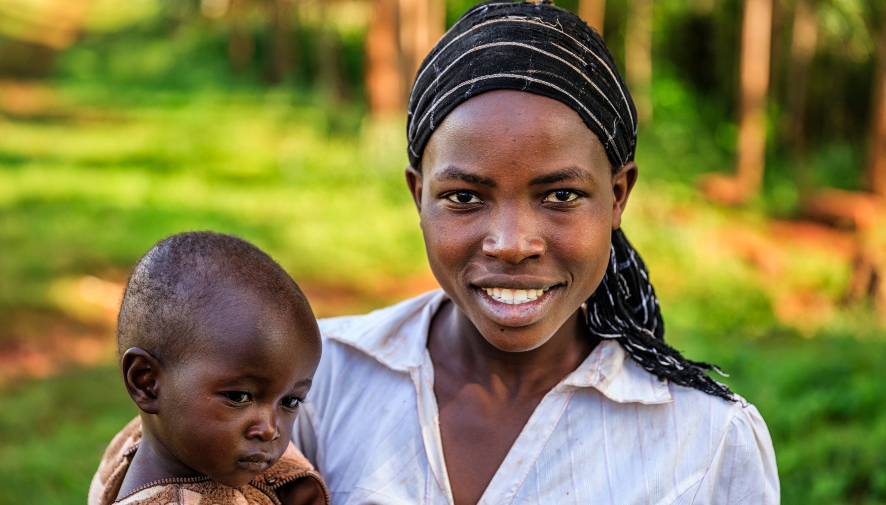 African woman smiling and holding a child