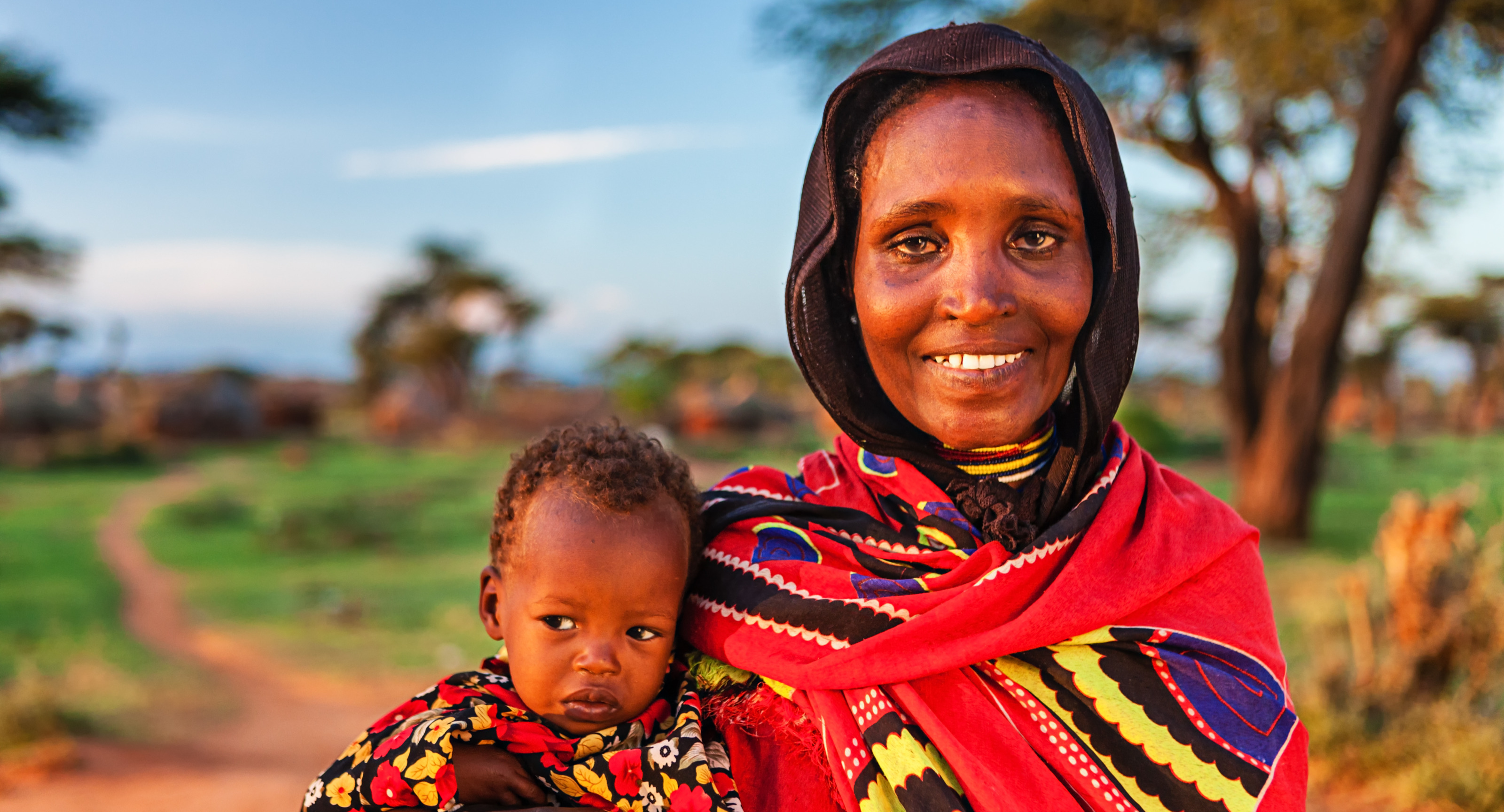 East african smiling and holding a child