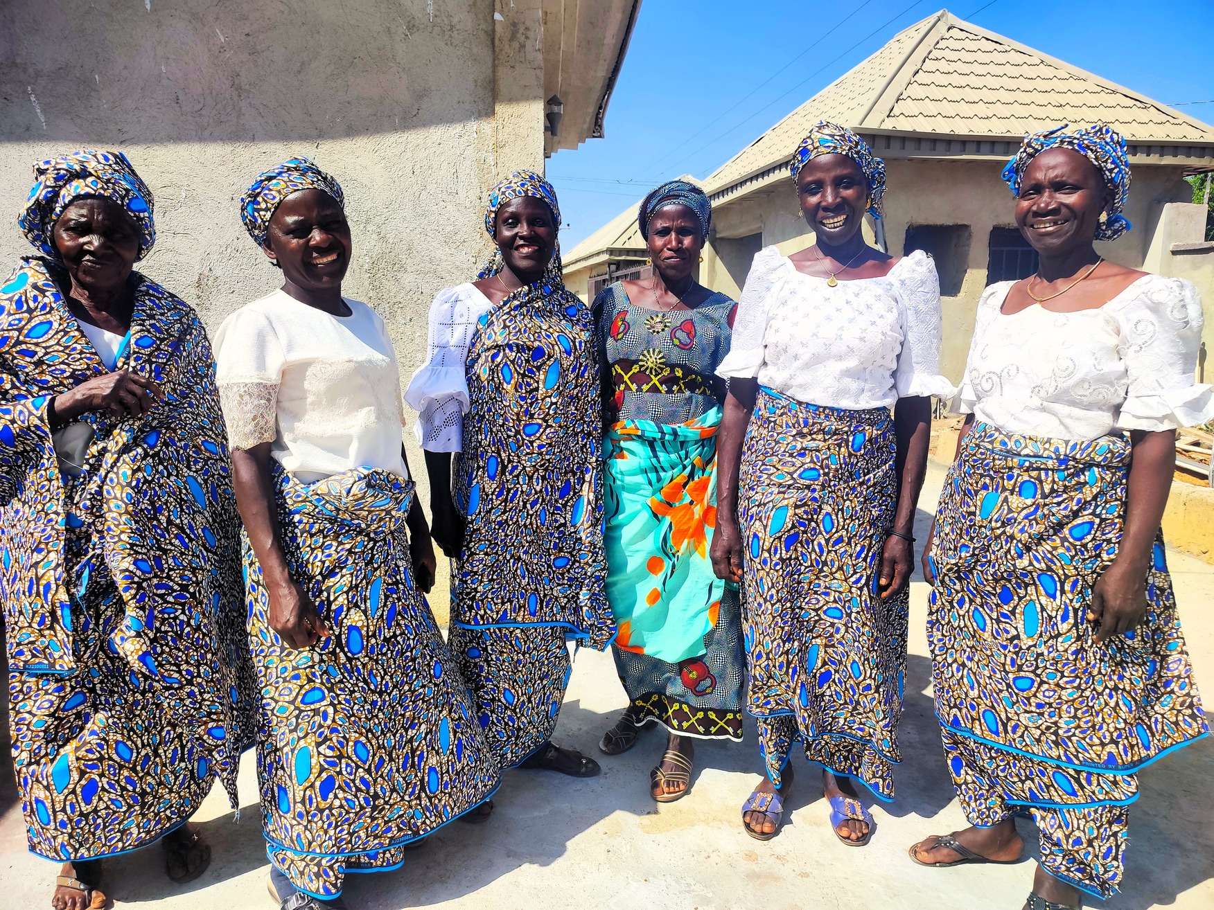 a group of woment standing and smiling